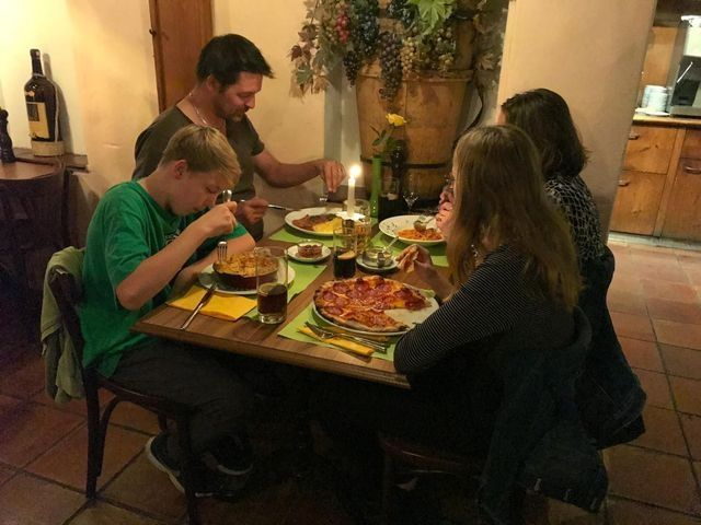 Gäste beim Abendessen mit Pizza und Wein in der Pizzeria Grottino