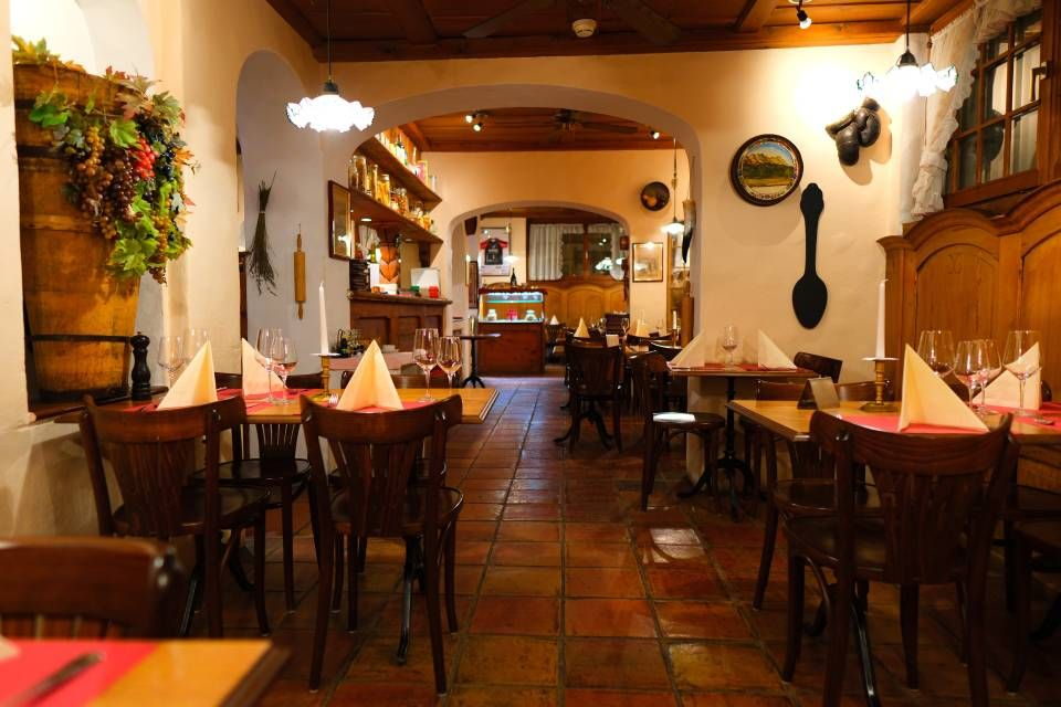 Gedeckte Tische mit weissen Tischtüchern in der Gaststube der Pizzeria Grottino