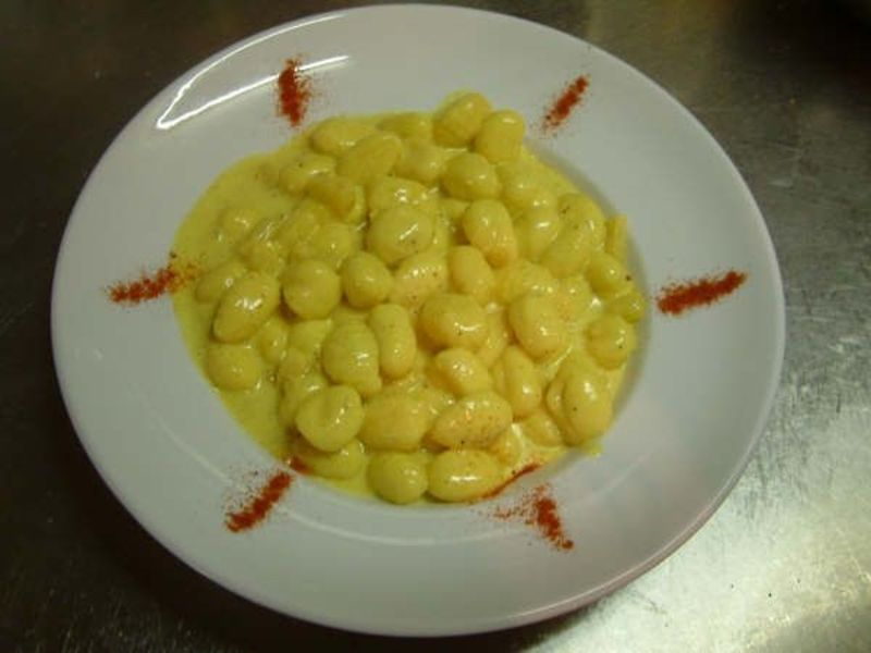 Kartoffel-Gnocchi an Curry-Rahmsauce, angerichtet auf weissem Teller