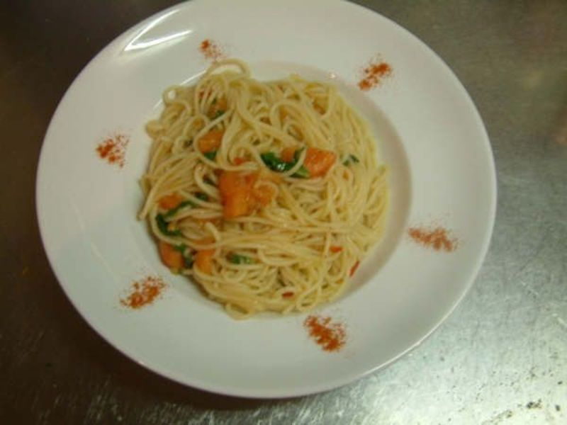 Spaghetti mit Kräutern und Gemüse auf weissem Teller