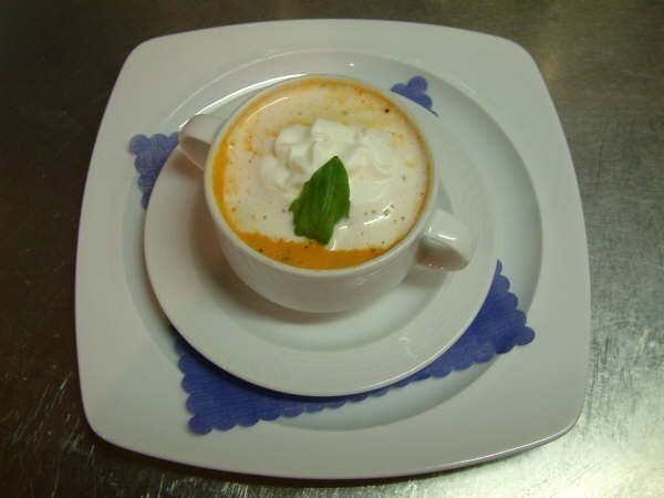 Cremesuppe in weisser Tasse mit frischem Basilikum